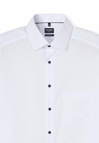 Weißes OLYMP-Hemd mit modernem Schnitt, ausgestattet mit klassischem Kragen, schwarzen Knöpfen, strukturierter Stoffqualität und einer einzelnen Brusttasche.