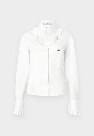 Blusa branca com botões, gola com folhos, decote recortado e punhos com folhos. Apresenta um pequeno detalhe bordado no peito.