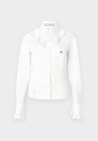 Blusa branca com botões, gola com folhos, decote recortado e punhos com folhos. Apresenta um pequeno detalhe bordado no peito.