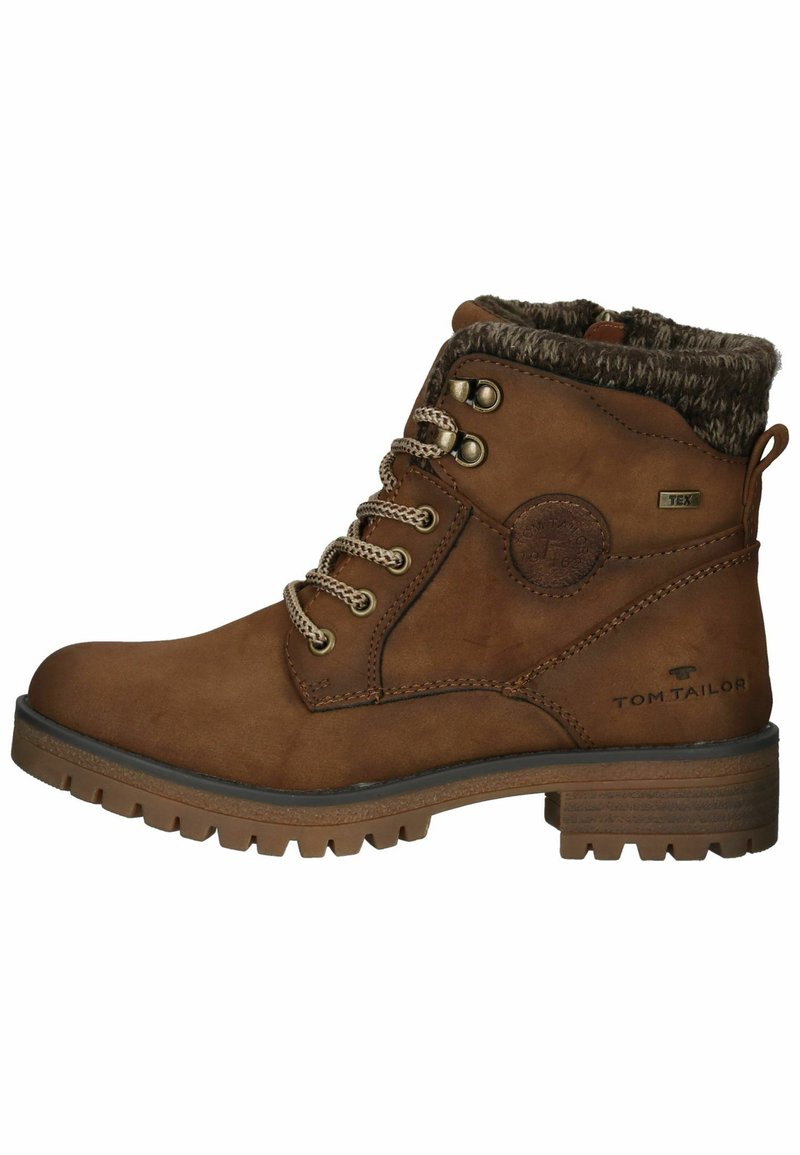 Bottines en cuir brun avec col en fausse fourrure, œillets en métal et lacets. Présente une semelle texturée et un logo TOM TAILOR sur le côté.
