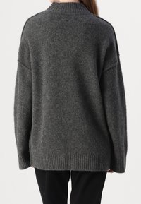 Oversized grijze wollen trui met een ribbelkraag en -zoom, voorzien van een zachte textuur en drop shoulders. Eenvoudig, functioneel ontwerp.