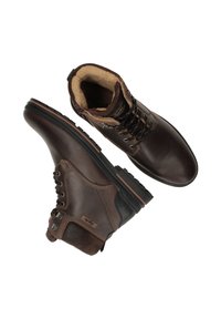 Bruine leren enkellaarzen met suède accenten, vetersluitingen, warme voering en robuuste rubberen zool, met lichte stiksels en een logo-detail.