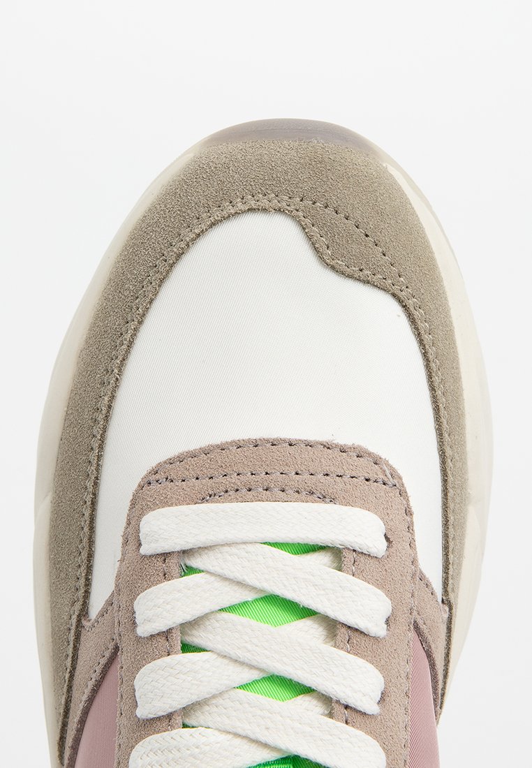 Sneaker met een witte stoffen bovenzijde, grijze suède accenten, beige overlays, groene veters en een gestructureerde rubberen zool.