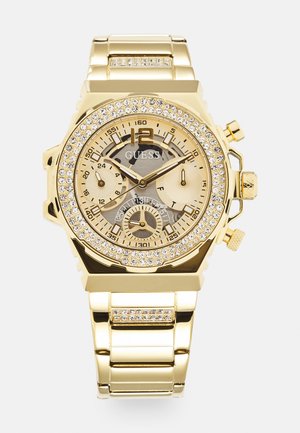 Orologio cronografo color oro con una lunetta adornata di cristalli, un quadrante dorato texturizzato, tre sottocampionatori e un bracciale in metallo.