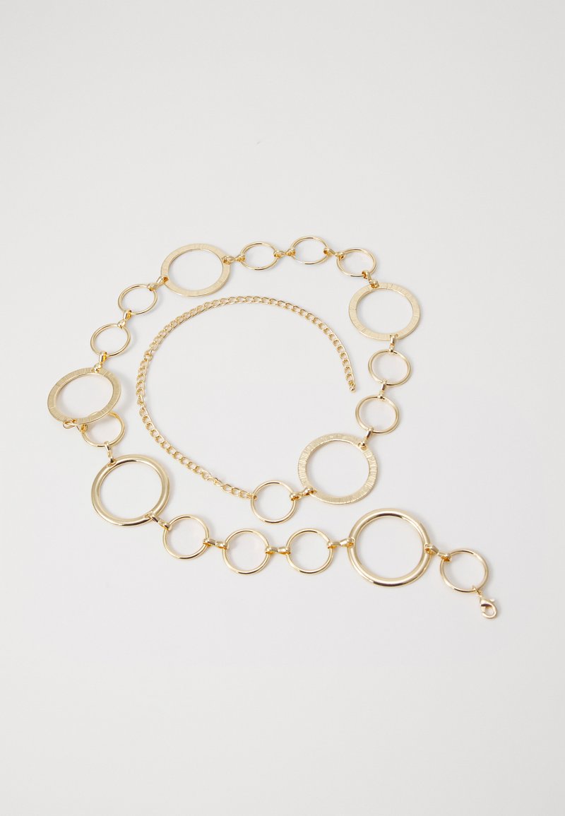 Gold-tone chain necklace featuring interlinked circular links of varying sizes, with a textured finish on select rings and a lobster clasp closure.
