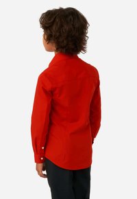 Maglietta rossa a maniche lunghe con colletto a punta, tessuto texturizzato, cucitura della spalla sul retro e polsini con un bottone. Vestibilità slim con orlo curvo.