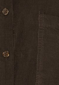 Mørkebrunt kord-velourstof med lodrette ribber, der har en lomme til højre og to mørkebrune knapper til venstre.