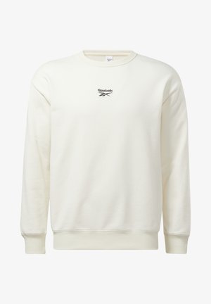 Sudadera crema hecha de tela suave, con cuello redondo, puños acanalados y un logo negro de Reebok en el pecho.