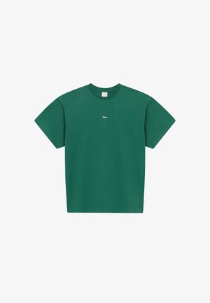 Zielona bawełniana koszulka z krótkim rękawem i okrągłym dekoltem, z małym białym logo na środku klatki piersiowej oraz beżową metką wewnątrz kołnierza.