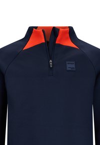 Polo navy con colletto alto, presenta accenti arancioni sulle spalle, una mezza cerniera e un patch rettangolare con logo sul petto.