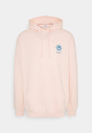 Lichtroze hoodie van zachte stof, met een voorzak, trekkoordcapuchon en een blauwe zonafbeelding met de tekst "SERENITY."