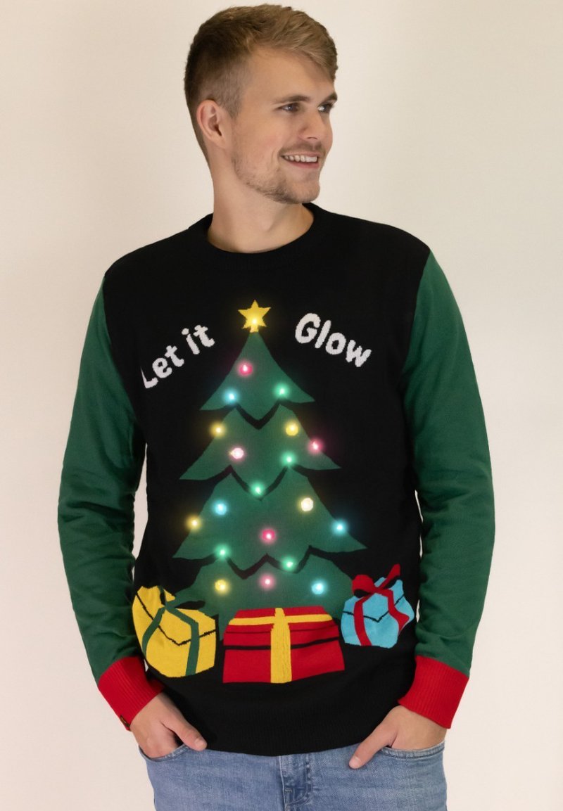Schwarzer Weihnachtspullover mit einem leuchtenden grünen Baum, bunten Ornamenten und Geschenken. Grüne Ärmel, rote Bündchen und weißer Text mit der Aufschrift "Let it Glow."