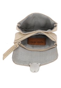 Beige stoffen portemonnee met een ritssluiting; de binnenkant heeft een zwart-wit gestreepte voering en een taupe leren label. Inclusief een metalen sluiting.