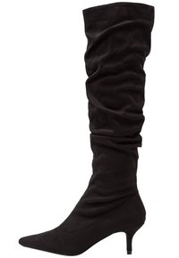 Bota de ante negro hasta la rodilla con punta afilada y un diseño suelto, que presenta un tacón delgado para mayor elevación.