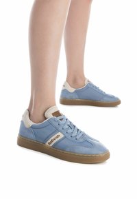 Zapatillas azul claro con una combinación de texturas suaves y de ante, con un talón beige y suela de goma marrón. Logo "Refresh" en el lateral.