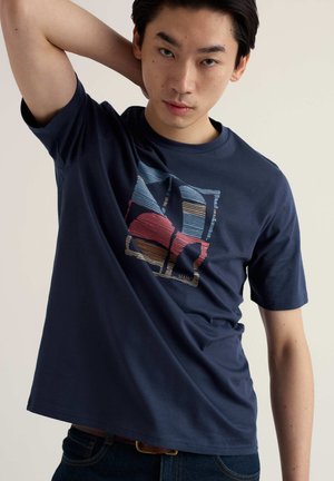 Donkerblauw katoenen T-shirt met een kleurrijk abstract grafisch ontwerp. Ronde hals en korte mouwen met een ontspannen pasvorm.