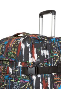 Stor hjulväska i svart tyg prydd med färgglada graffiti-inspirerade mönster, inklusive abstrakta former och text.