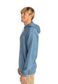 Sudadera de algodón azul con bolsillo tipo canguro, capucha con cordón y logotipo bordado en la parte delantera. Textura suave y corte relajado.