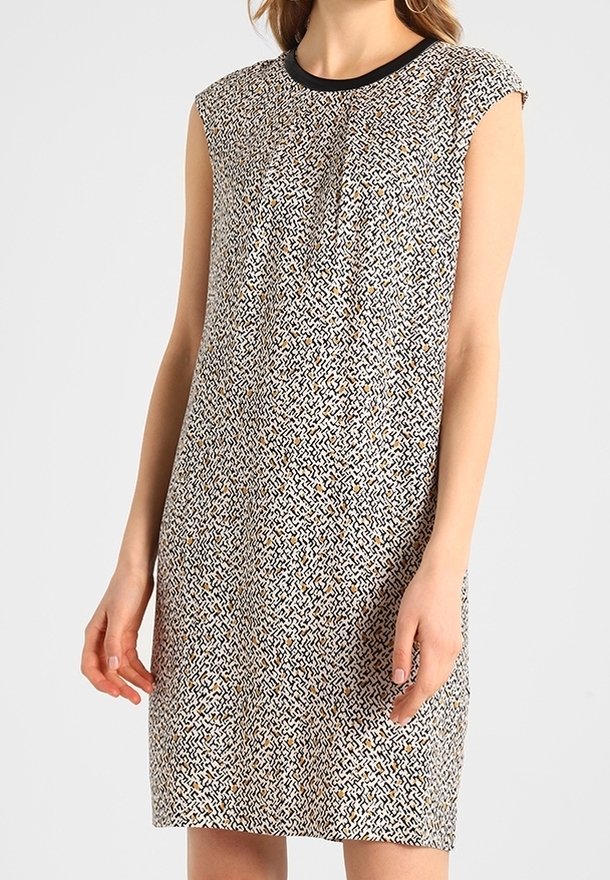 Mönstrad ärmlös klänning med rund halsringning och lös passform. Texturerad vit bas med svarta och gyllene abstrakta mönster.