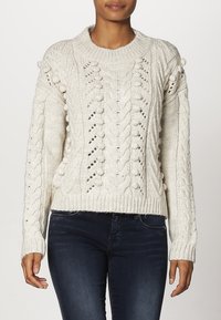 Gruby kremowy sweter dziany ze wzorem warkocza, ozdobiony wypukłymi oczkami oraz z zaokrąglonym dekoltem. Długie rękawy z ściągaczami na mankietach i u dołu.
