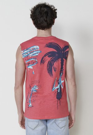 T-shirt sans manches rouge avec un graphique de palmier et des textes en encre bleue et marine, offrant une coupe décontractée et une texture douce.