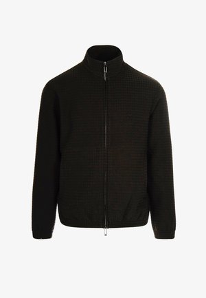 Giacca nera con zip, caratterizzata da un motivo trapuntato e testurizzato, colletto alto e polsini elasticizzati. Presenta un piccolo logo sul petto. Tessuto leggero.