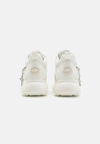 Weiße Sneakers mit einer strukturierten Oberseite, featuring ein Logo auf der Ferse und einer dekorativen Kettenakzent an der Seite. Abgerundete Sohle.