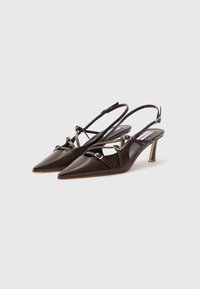 Décolleté slingback in pelle verniciata marrone con punta affusolata, cinturini regolabili e piccoli inserti metallici sulla parte anteriore.