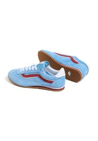 Niebieskie zamszowe sneakersy z czerwonymi akcentami i białymi sznurówkami. Perforowany wzór po bokach, gumowa podeszwa z teksturowanym gripem i biała tylna pętla.