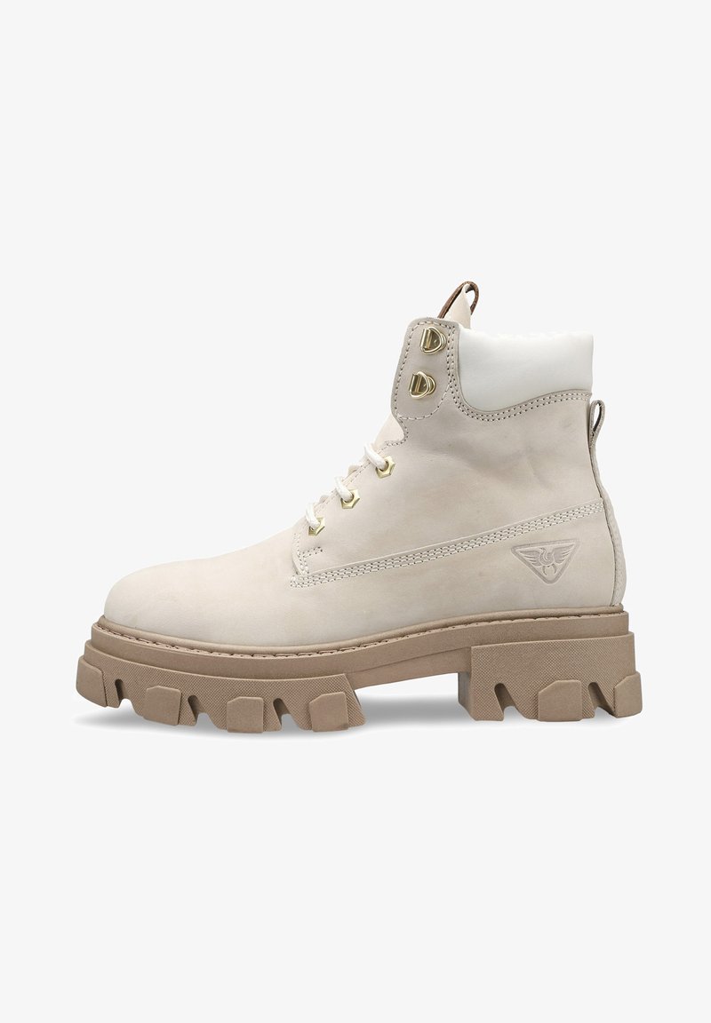 Beige Wildleder-Ankelboot mit einer dicken Gummisohle, metallischen Ösen und einer runden Zehe. Weißer gepolsterter Schaft und Logo an der Seite.