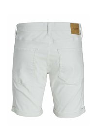 Bermudas de mezclilla blanca con puños enrollados, que presentan dos bolsillos traseros y una etiqueta de piel marrón de la marca en la cinturilla.