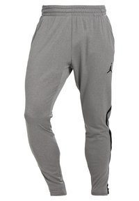 Graue Sporthose mit elastischem Bund, tailliertem Schnitt und schwarzem Jordan-Logo am linken Oberschenkel. Mit seitlichen schwarzen Akzenten.