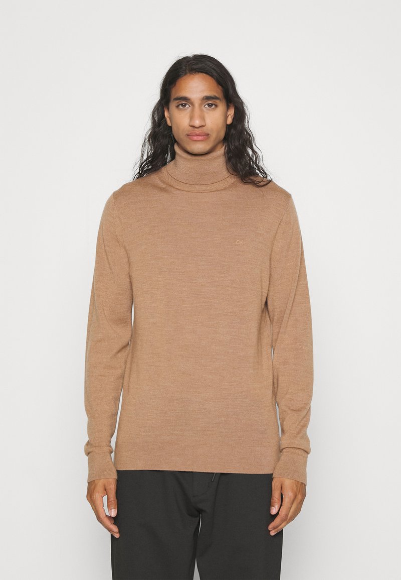 Maglione a collo alto marrone chiaro realizzato in tessuto morbido, con un design aderente, maniche lunghe e un leggero accento del logo sul petto.