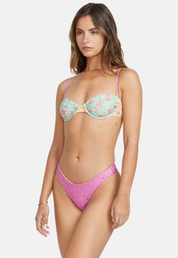 Bikini set s květinovým vzorem v tyrkysové a žluté barvě, bandeau top s pevným pink texturovaným vysokým pasem. Obsahuje tenké ramínka.