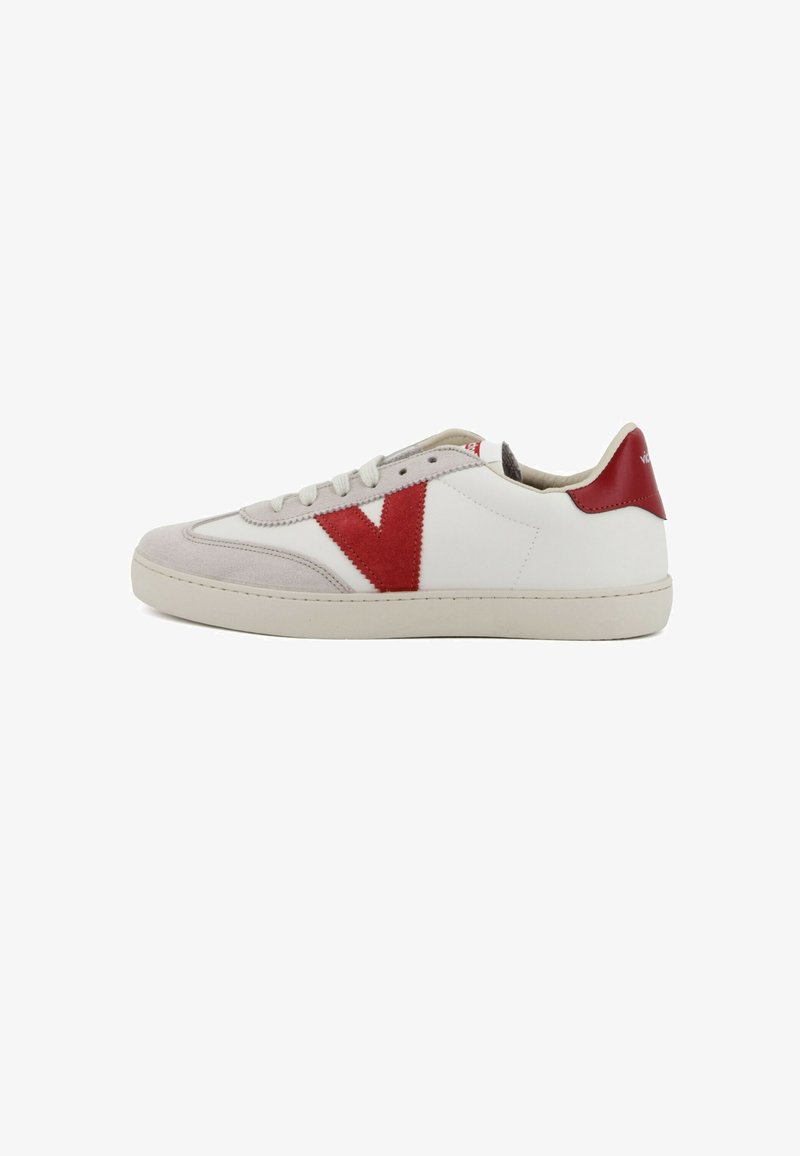 Baskets basses blanches avec un logo "V" en suède rouge sur le côté, un talon rouge, une semelle beige et un bout en suède beige.