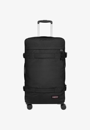 Zwarte koffer op wielen met uittrekbare handgreep, gemaakt van duurzaam stof, voorzien van ritsvakken, gespen en een logo patch.