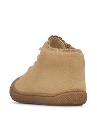 Bruna mocka ankelboot med strukturerad sula och snörning. Vågmönstrad kantdetalj på kragen ger designintresse.