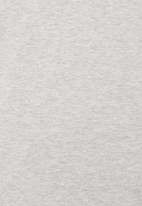 Tejido gris claro con una textura sutil, compuesto por un material suave y de punto. La superficie es uniforme con mínima variación de color.