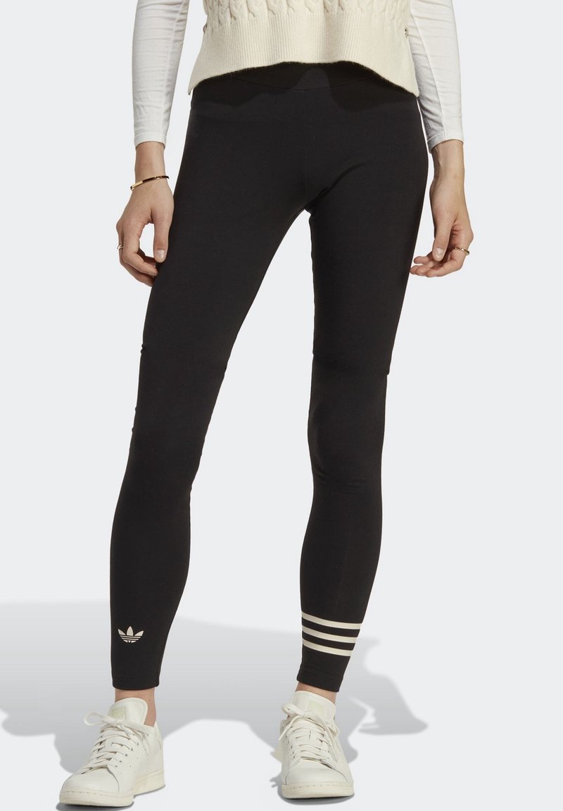 Mustat leggingsit, joissa on istuva muotoilu. Yksityiskohtina kolme valkoista raitaa nilkassa ja pieni logo. Valmistettu joustavasta materiaalista mukavuutta varten.
