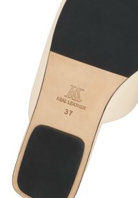 Semelle de chaussure en cuir beige avec talon et embouts noirs, marquée du logo "KS Real Leather" et de la taille 37.
