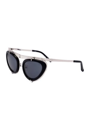 Occhiali da sole con montatura argento, lenti spesse nere triangolari scure e sottili aste argento con punte nere su sfondo bianco.