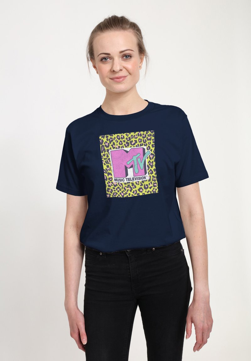 Camiseta azul marino con un gráfico central en rosa y verde con acentos de estampado de leopardo, que muestra el texto "MTV MUSIC TELEVISION".