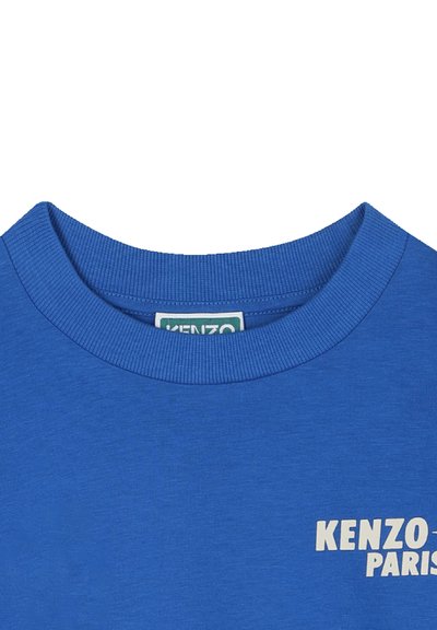 T-shirt en coton bleu avec un col rond côtelé, présentant "KENZO PARIS" imprimé en blanc à l'avant. Texture lisse, design décontracté.
