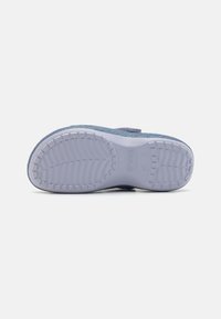 Talpa de pantof slip-on cu glitter albastru, cu un fund din cauciuc alb texturat, având o modelare pentru aderență și confort.