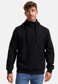 Haut à capuche noir avec un motif géométrique texturé, une poche kangourou et des cordons de serrage. Le tissu est doux, avec des poignets et un ourlet côtelés.