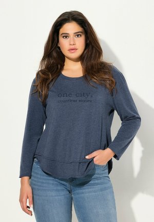 Marineblaue Langarmbluse mit rundem Ausschnitt, versehen mit dem Text "eine Stadt, unzählige Geschichten" in einem leicht erhabenen Design.