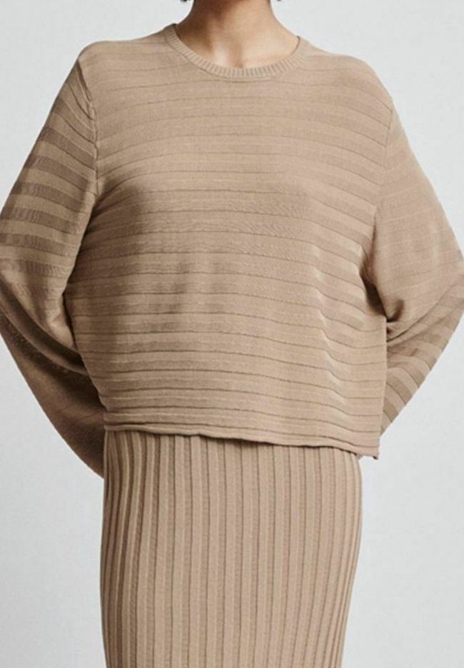 Beige pletený svetr s horizontálními pruhy, širokými rukávy a kulatým výstřihem, doplněný o odpovídající žebrovanou sukni. Měkká textura.