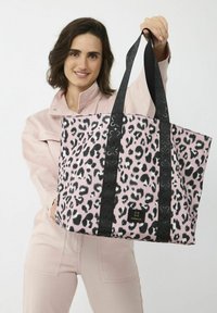 Roze luipaardprint tote bag met zwarte handvatten en een merketiket. De tas heeft een gestructureerde, rechthoekige vorm en is gemaakt van zacht materiaal.