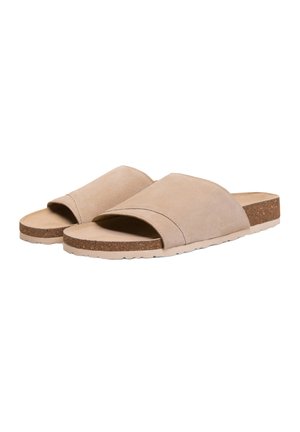 Sandalias beige de ante con punta abierta, sin cierre, con plantillas de corcho y suelas de goma de color claro, mostradas lado a lado sobre un fondo blanco.