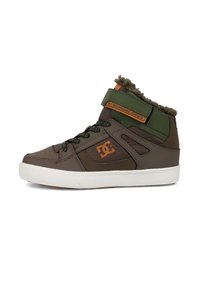 Hnědé a zelené vysoké tenisky s texturovaným povrchem, vybavené suchým zipem, polstrovaným límcem a bílou gumovou podrážkou s protiskluzovým vzorem.